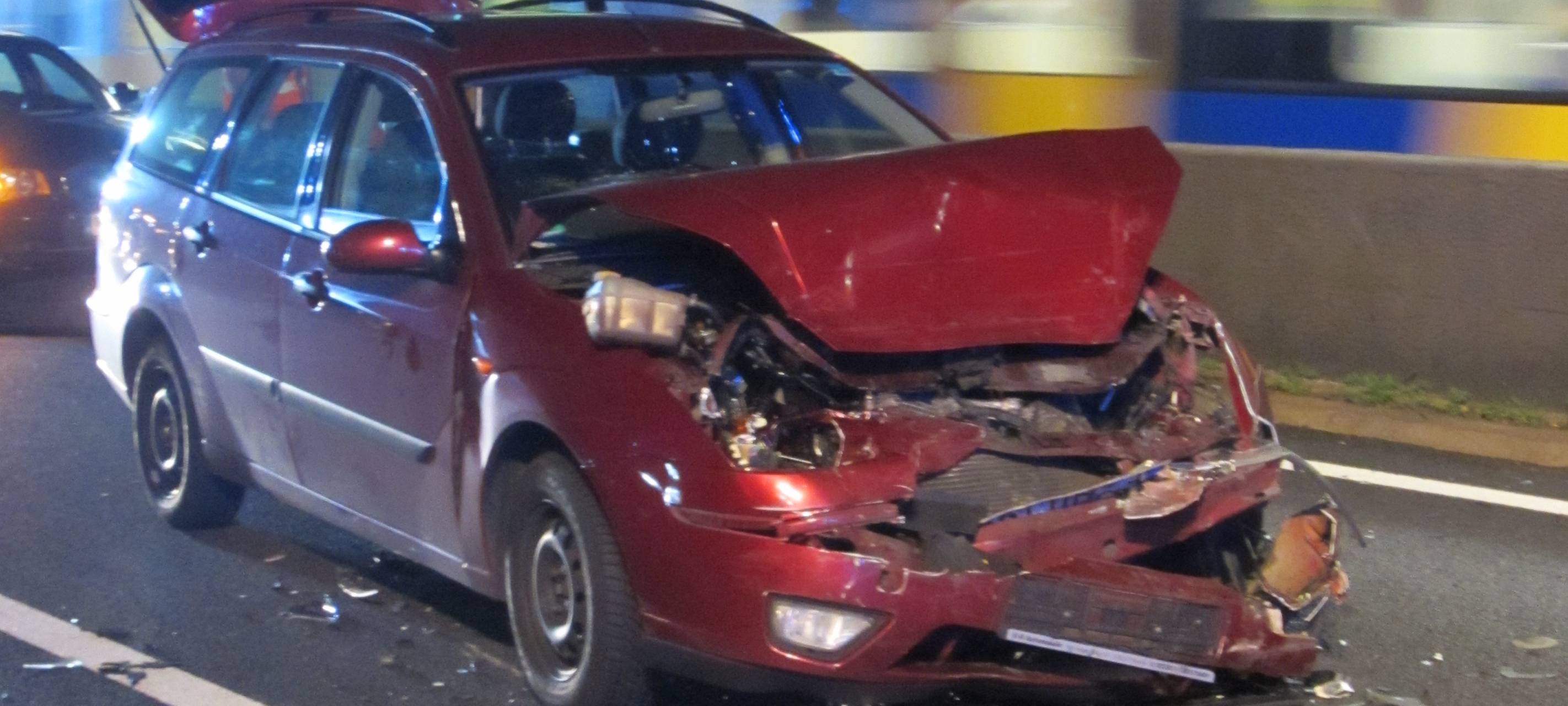 Ein roter Kombi mit komplett zerbeulter Front ist auf dem Bild. Der Wagen krachte ungebremst in ein Stauende.