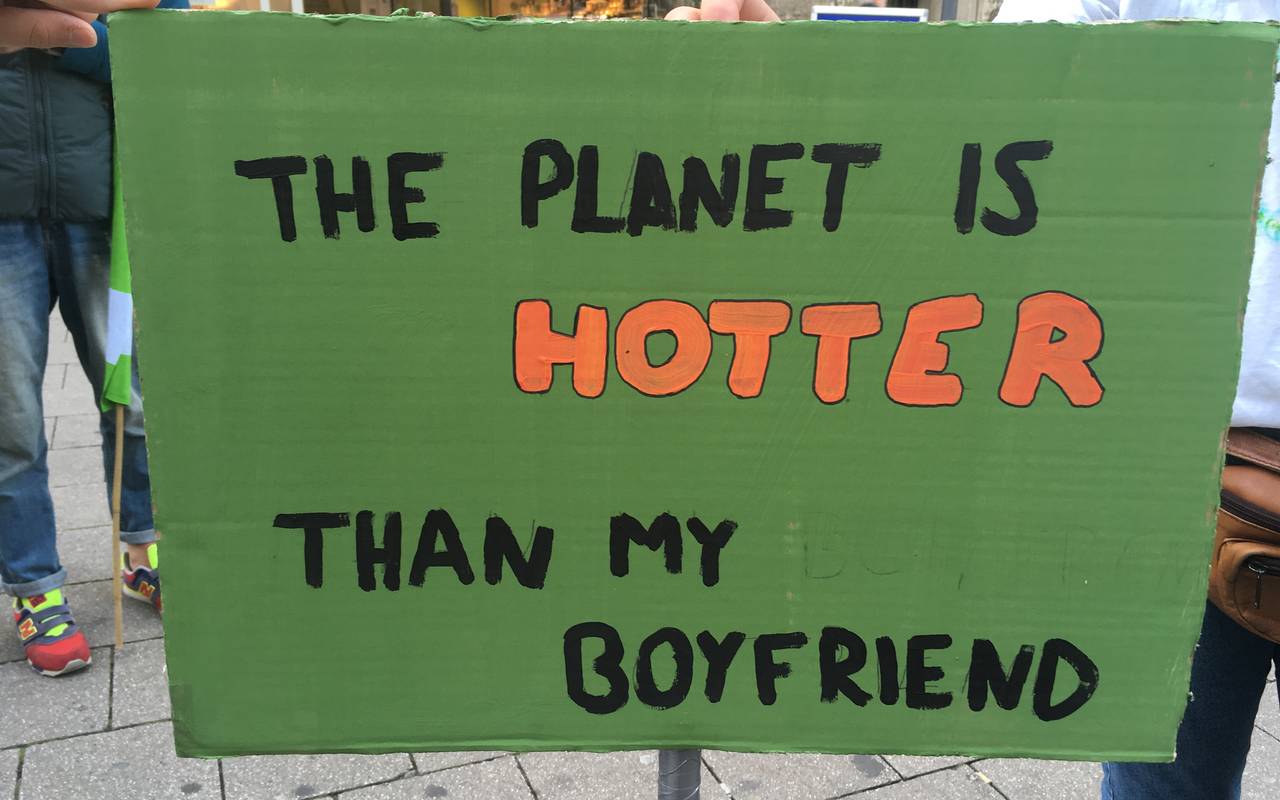 Demoplakat auf dem "The planet is hotter than my boyfriend" steht.