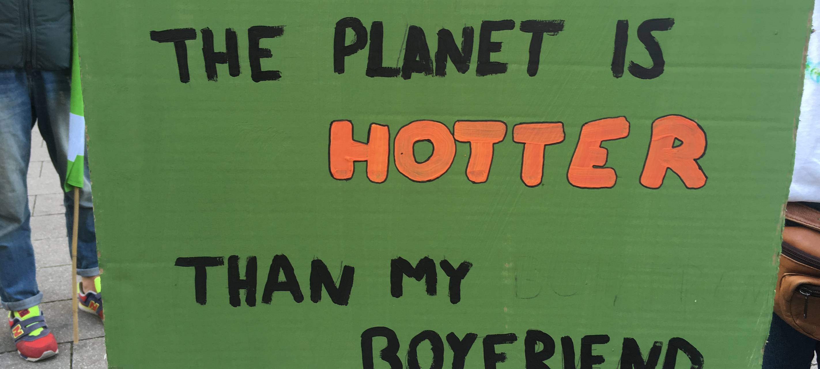 Demoplakat auf dem "The planet is hotter than my boyfriend" steht.
