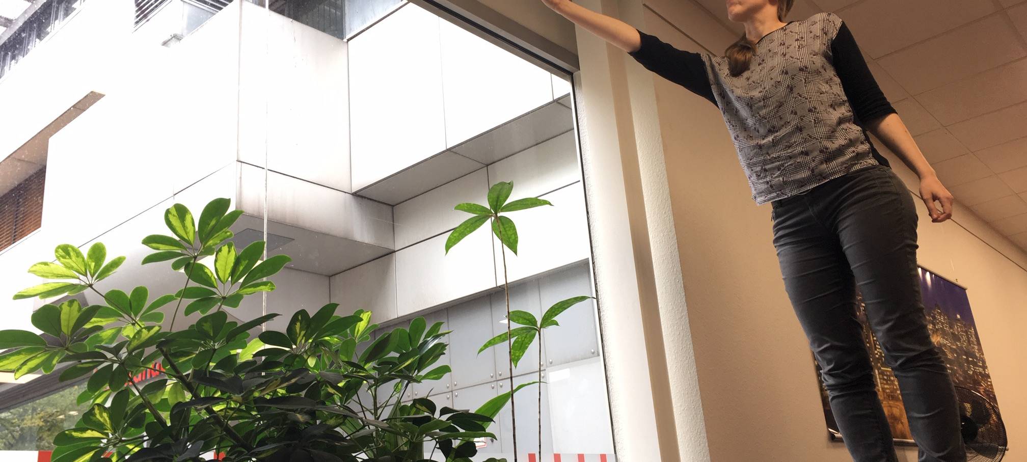 Larissa Schmitz von Radio Essen sucht mit ihrem Handy auf dem Schreibtisch am Fenster nach gutem Empfang.