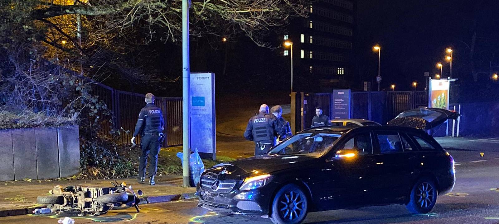 Das Foto zeigt den Unfallort. Der Roller liegt am Boden, das Auto ist nur an der Front beschädigt.