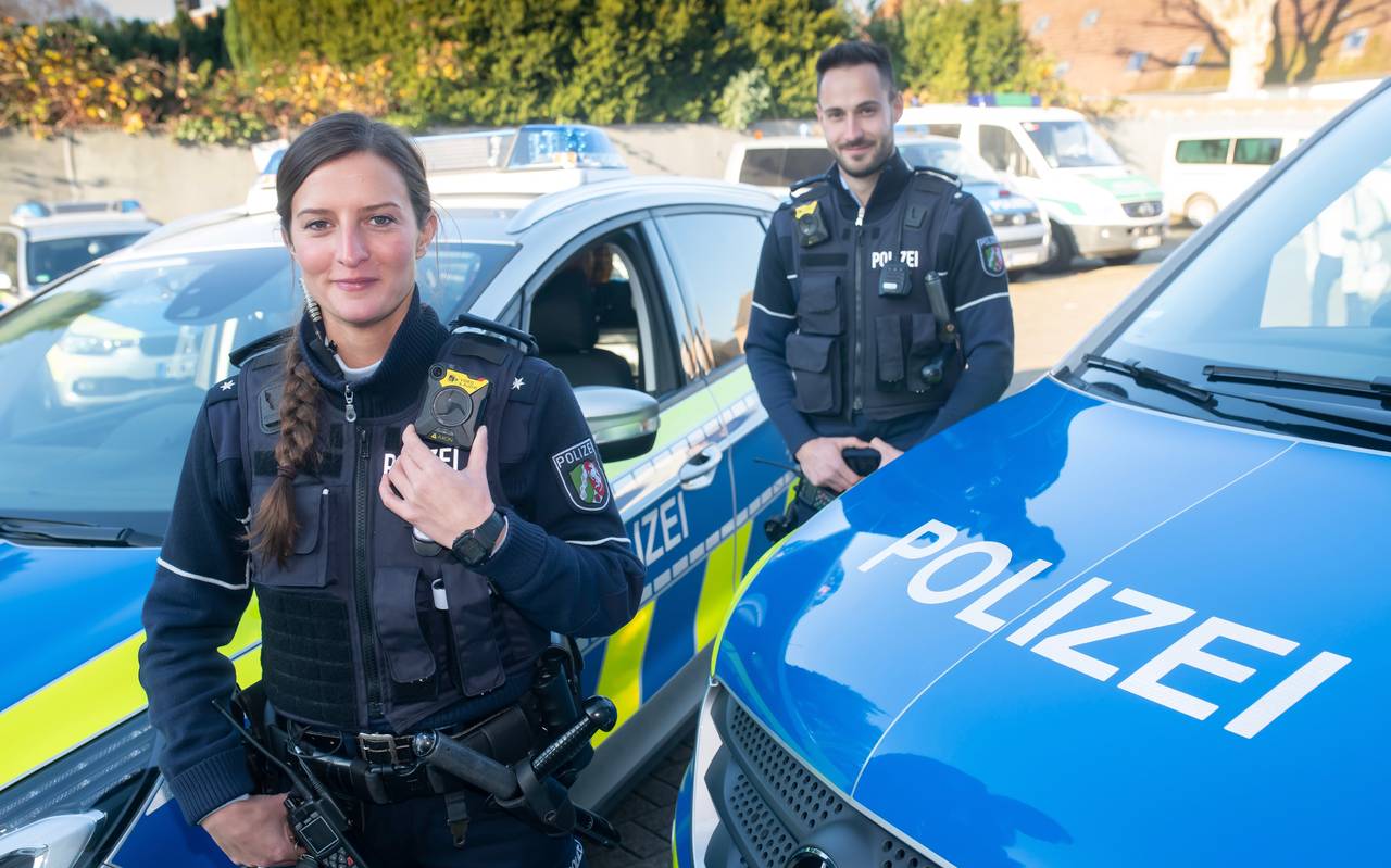 Zwei Polizeibeamte präsentieren ihre neue Ausstattung: Bodycams. 