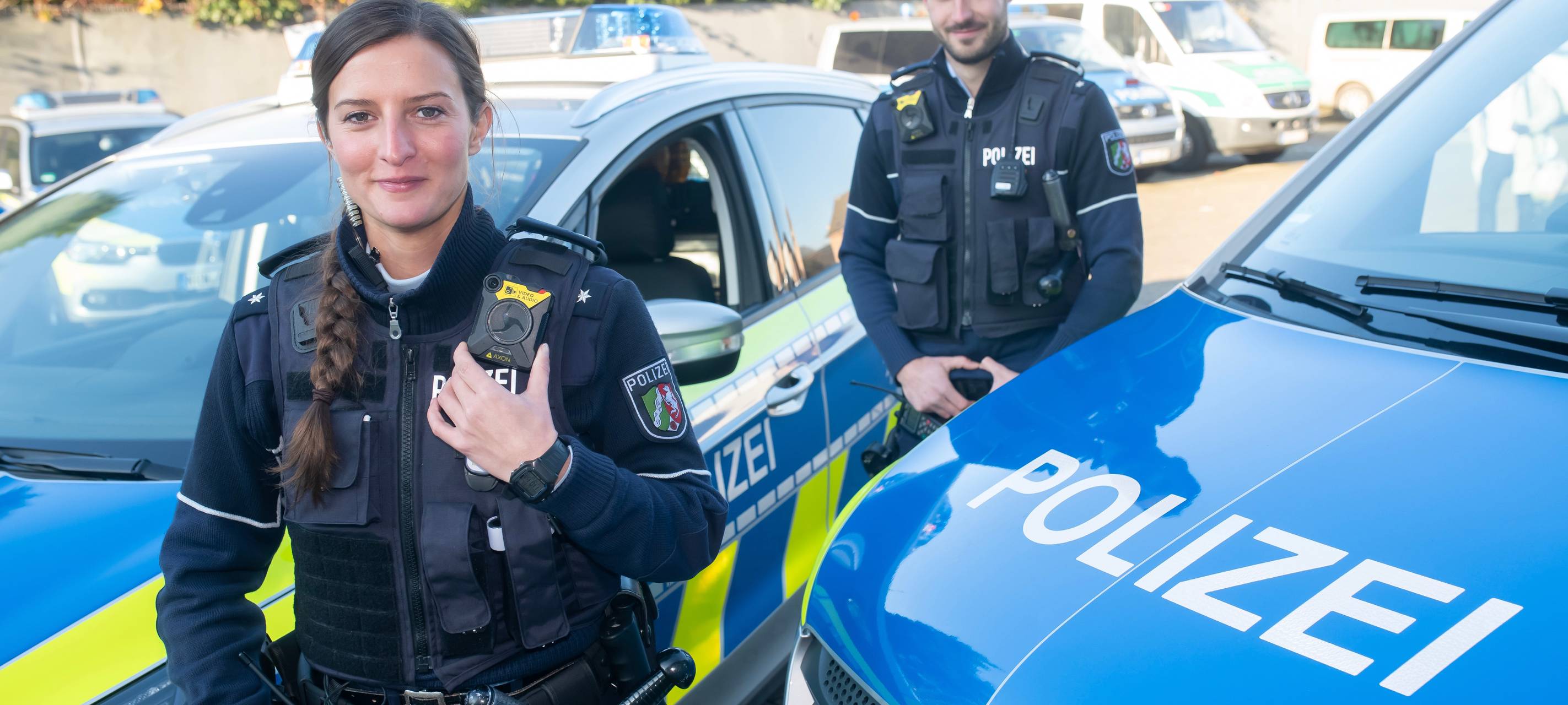 Zwei Polizeibeamte präsentieren ihre neue Ausstattung: Bodycams.