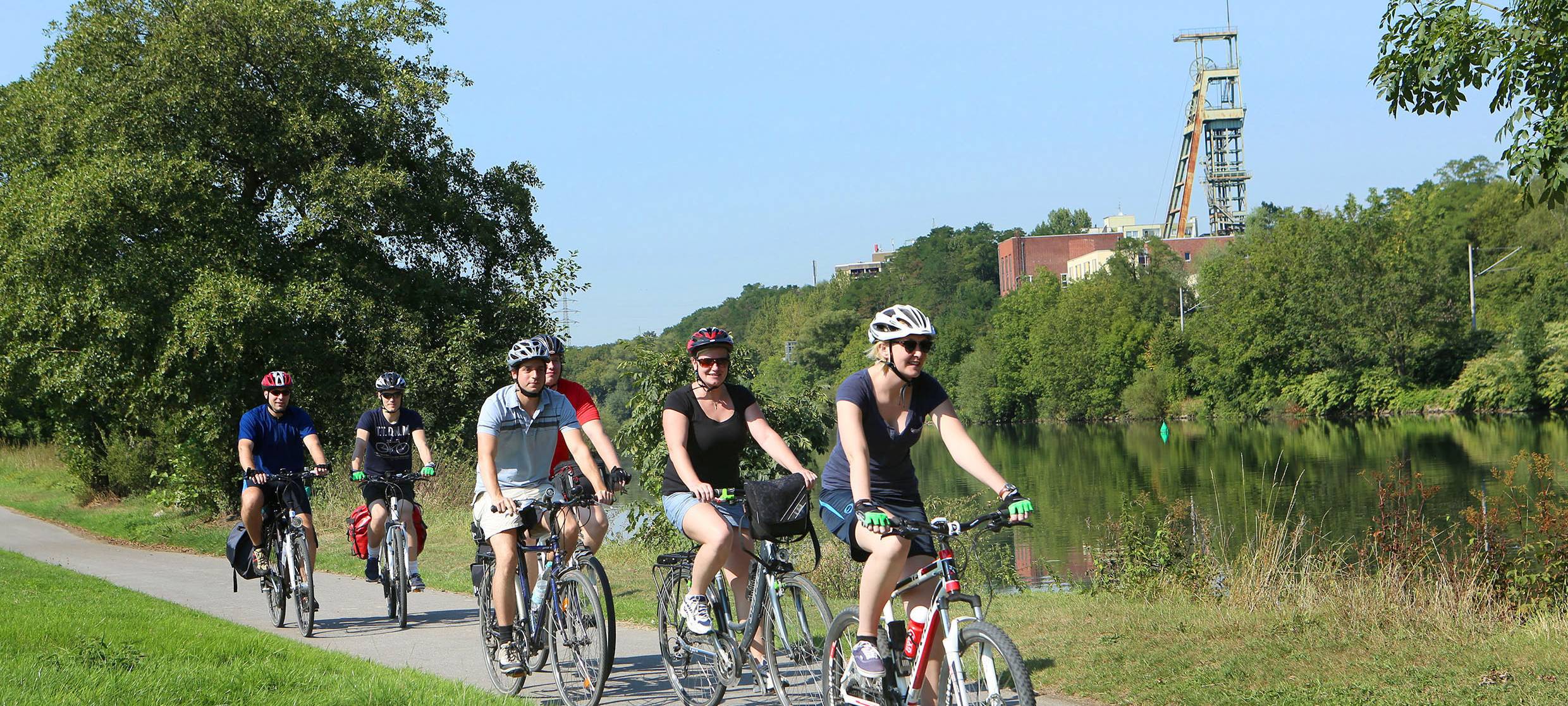Auf dem Bild radelt eine Gruppe Fahrradfahrer an der Ruhr entlang.