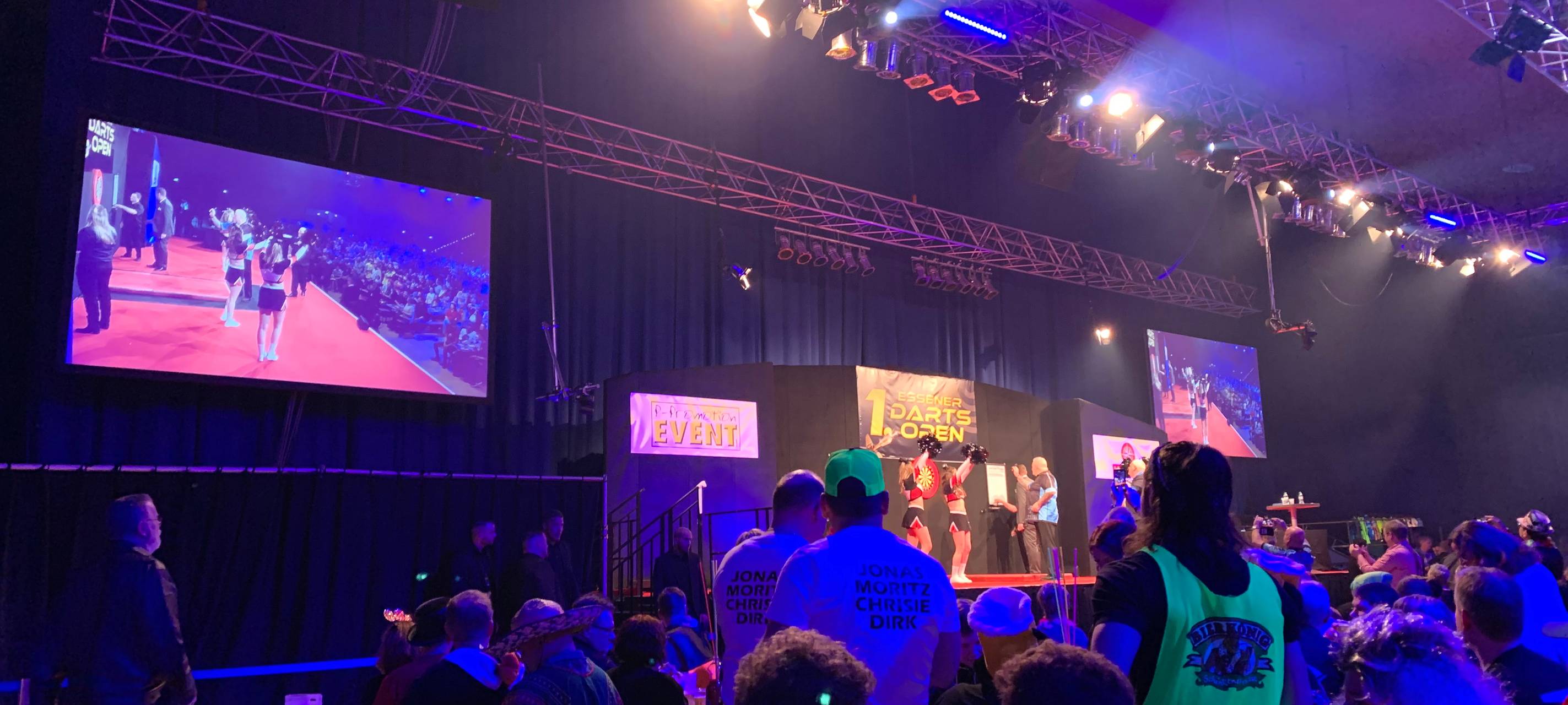 Über großen Bildschirmen neben der Bühne wird das Tunier live übertragen.