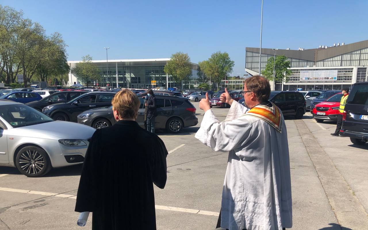 Pfarrerin Jacobs und Pastor Wolharn winken jedem Auto.