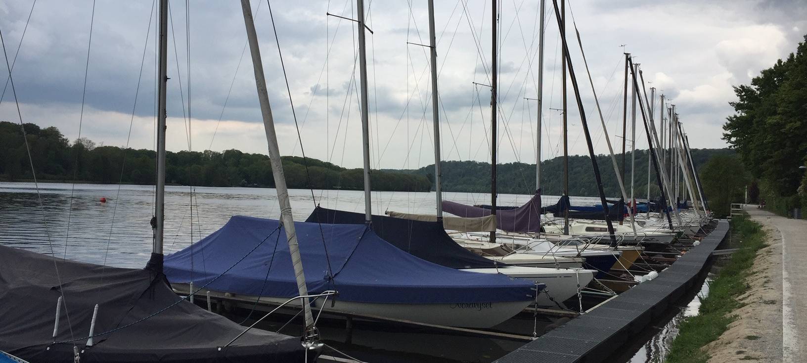 Segelboote liegen unter Planen am Baldeneysee in Essen.