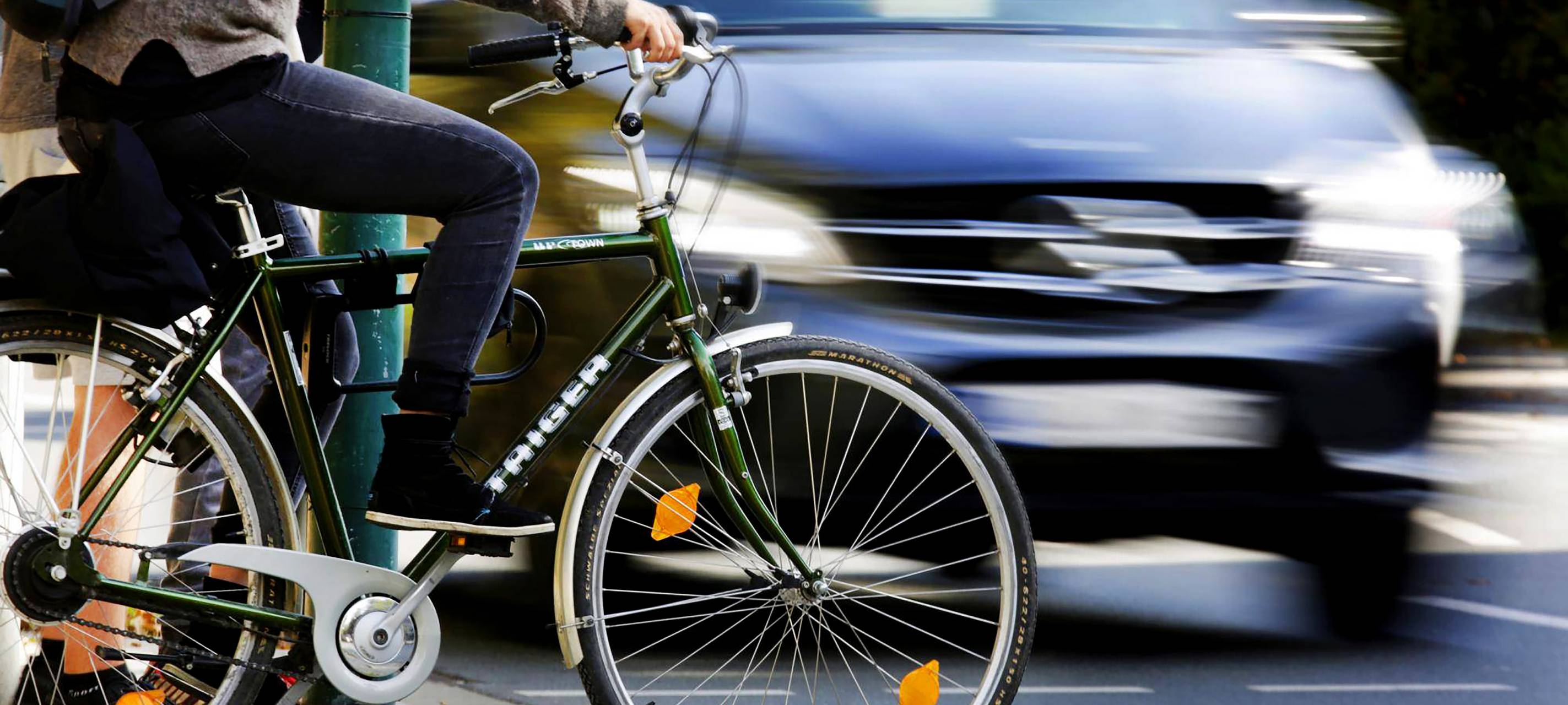 Fahrrad und Auto im Straßenverkehr an Ampel