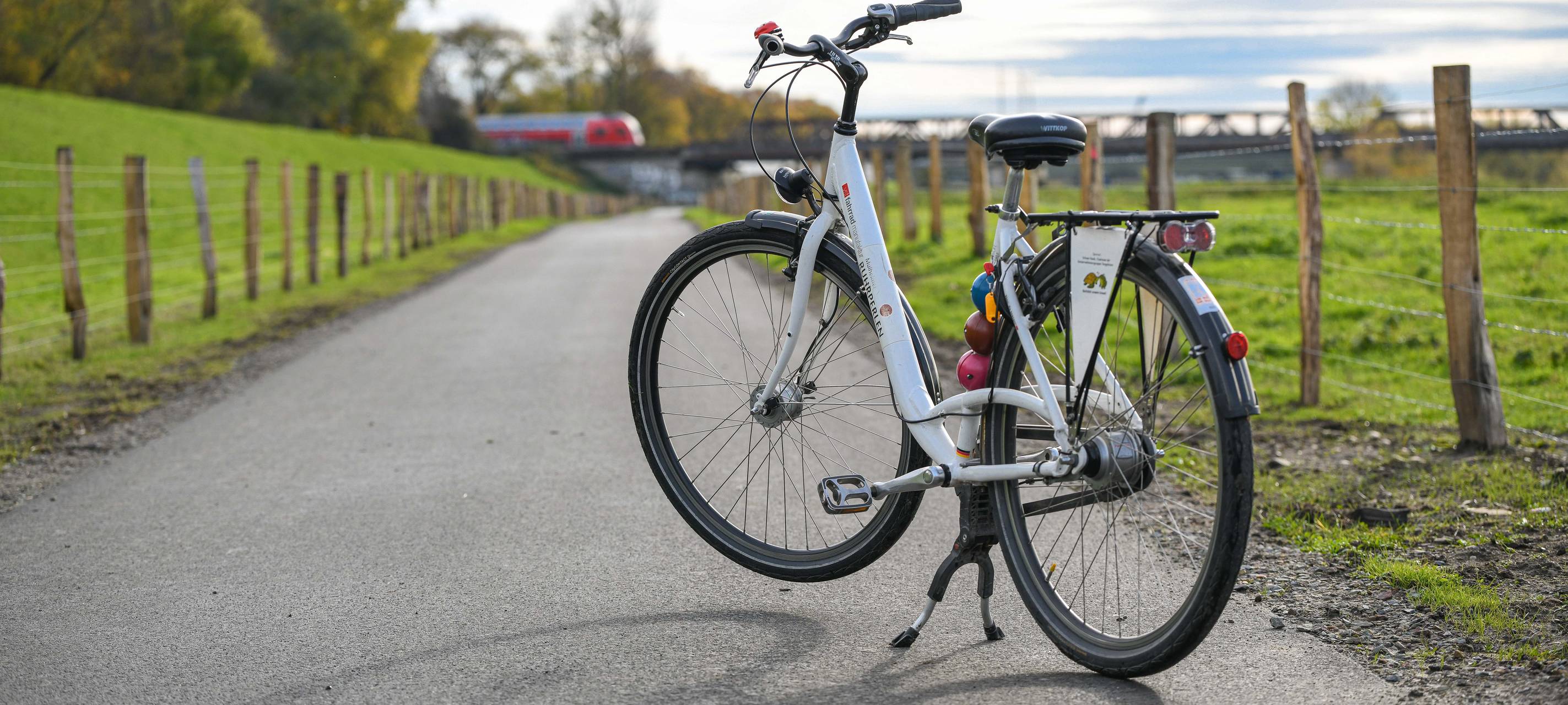 Fahrrad an der Ruhr in Oberhausen vor einer Brücke mit Zug