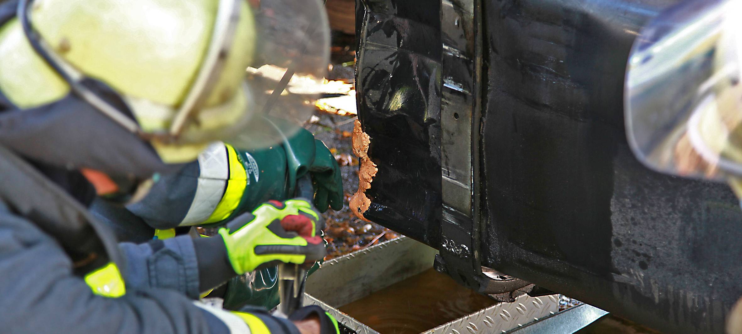 Erstmaßnahmen nach LKW-Unfall mit Kraftstoff-Austritt in Essen: Die braune Paste muss mit der Hand anmodelliert werden - eine provisorische Maßnahme.