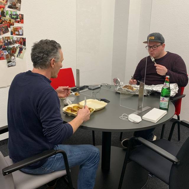 Stadtreporter Kostas Mitsalis und Tobi Bitter sitzen am Tisch und Essen
