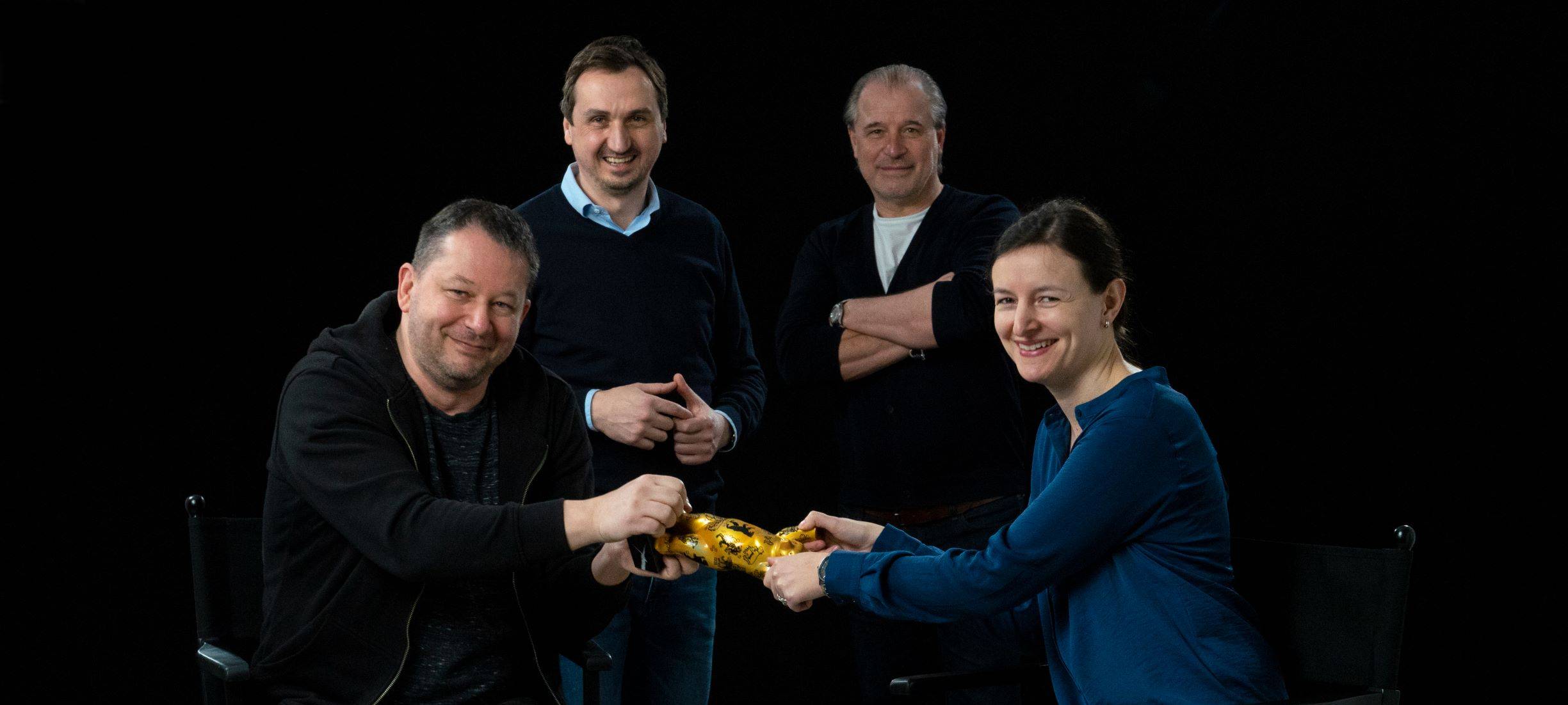 Der Essener Imagefilm "Das goldene Stadttor" hat Gold bei einem Internationalen Filmwettbewerb bekommen. Die Beteiligten stehen bei einem Foto versammelt vor einer schwarzen Leinwand.