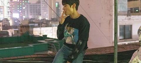 Das Bild "Snakepool" von 2020 zeigt einen jungen Asiaten rauchend auf einem Dach in der Vorstadt.