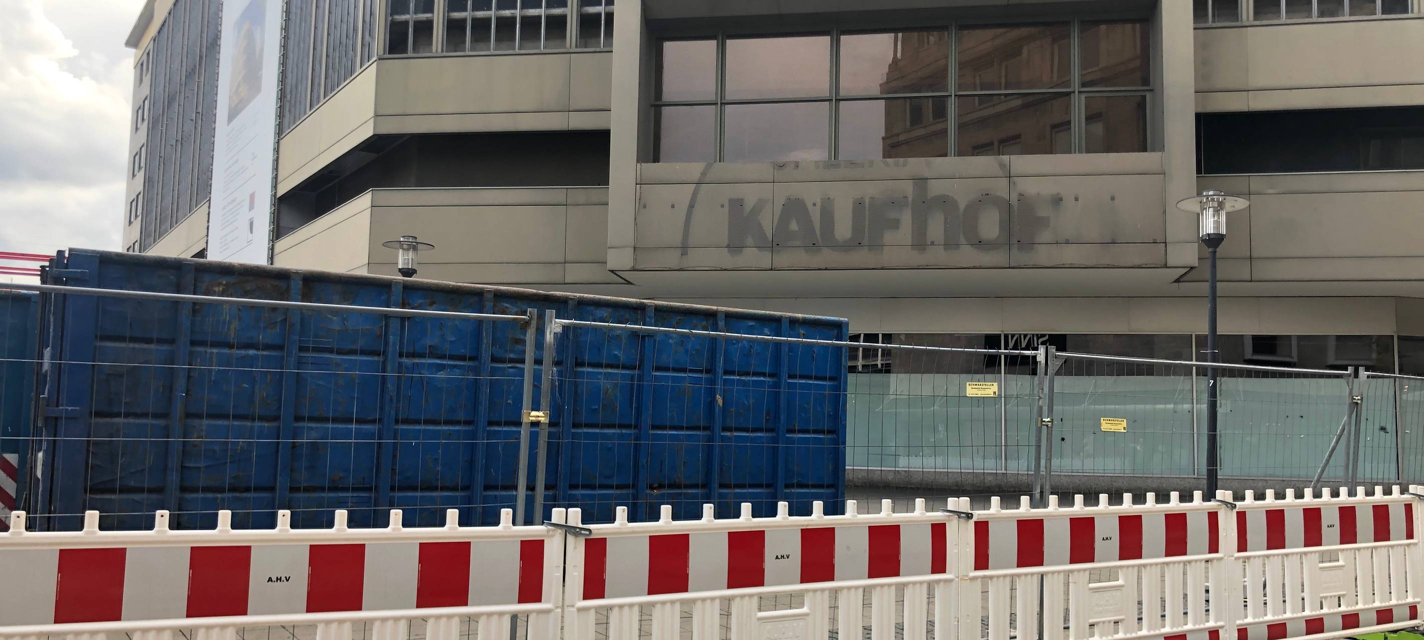 Die Bauarbeiten am alten Kaufhof-Gebäude in Essen gehen in die nächste Runde. Rund um den Willy-Brandt-Platz stehen Bauzäune und ein Container. Der Name von Kaufhof ist abmontiert werden.