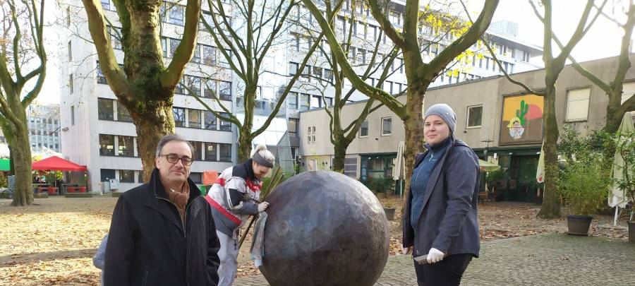 Das Kunstwerk "Ein leichtes Spiel" mit seinen Stahl-Elementen am Salzmarkt wird gereinigt. Kulturdezernent Muchtar Al Ghusain (links), und Mitarbeiterinnen der Restaurationsfirma "Zur Schmiede" Clara Buchegger (Mitte) und Anna Windmüller (rechts).