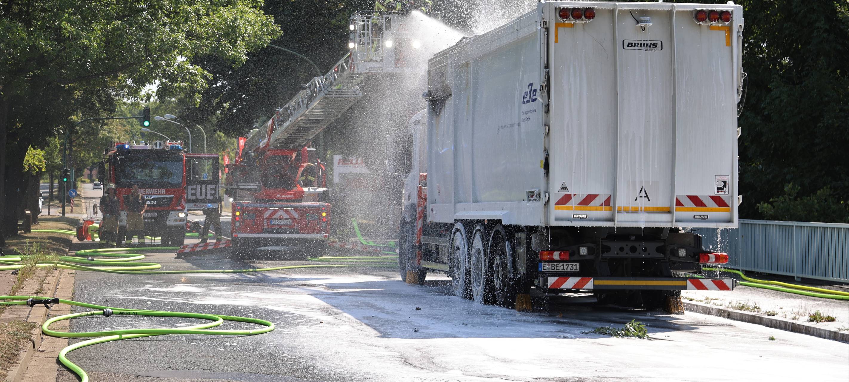 Die Feuerwehr spritzt Schaum in den Container.