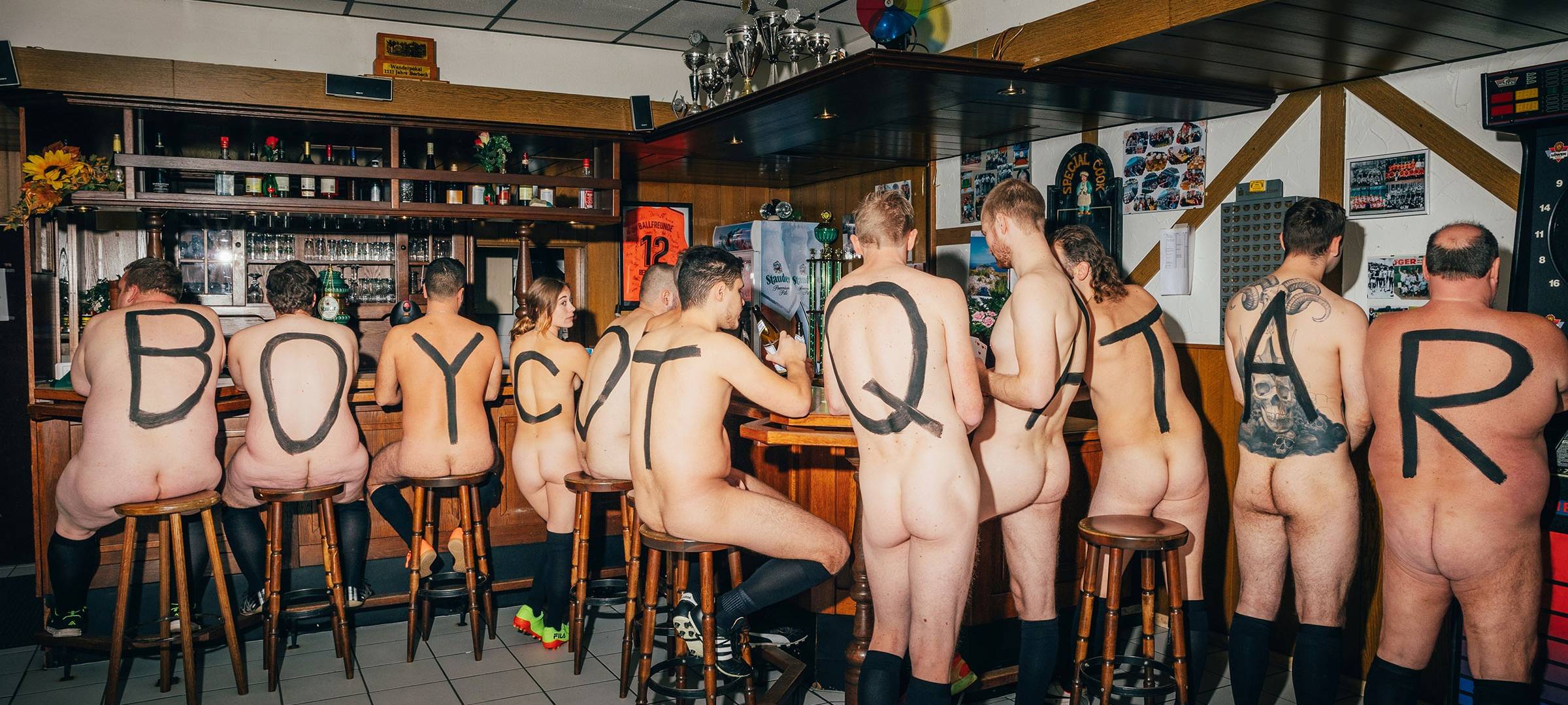 Nackte Menschen in Essen mit "Boycot Quatar" auf dem Rücken