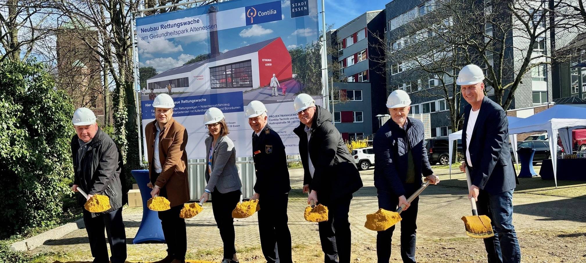 7 Personen mit einem Spaten in der Hand.