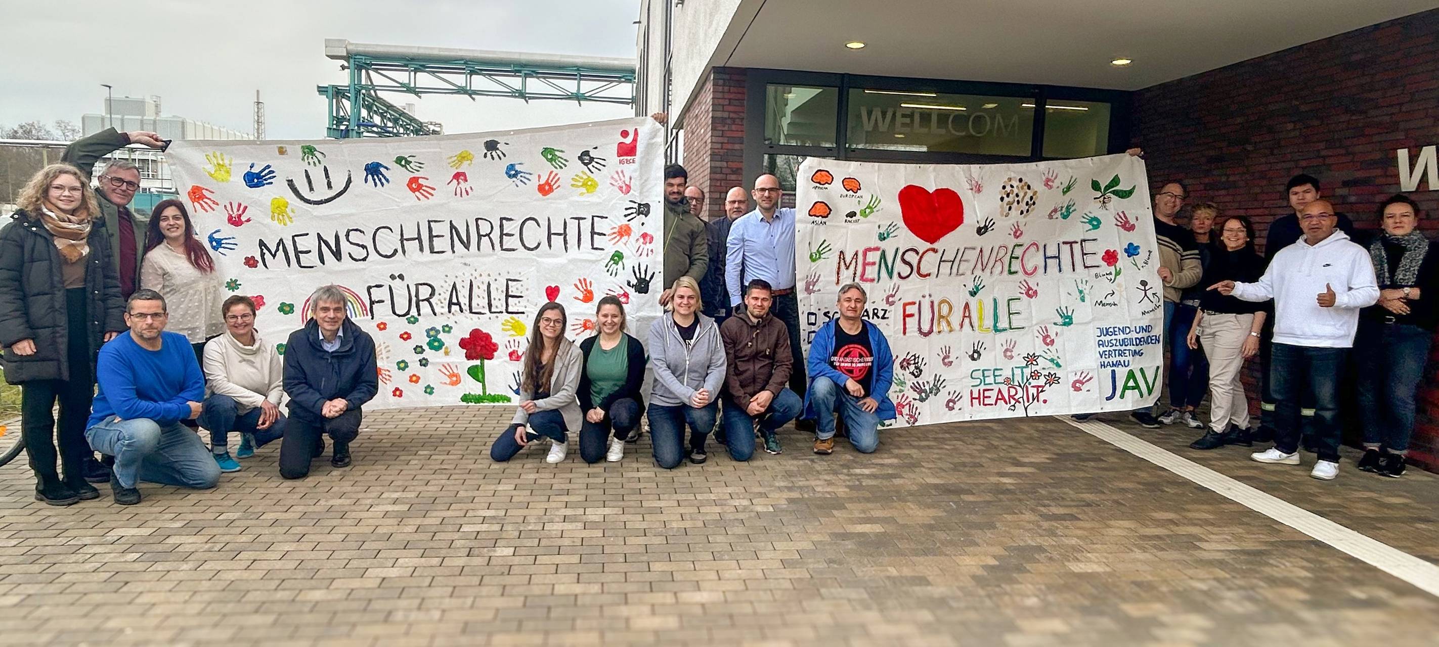 Auszubildende und Arbeitnehmervertreter von Evonik halten Plakate mit der Aufschrift "Menschenrechte für alle".