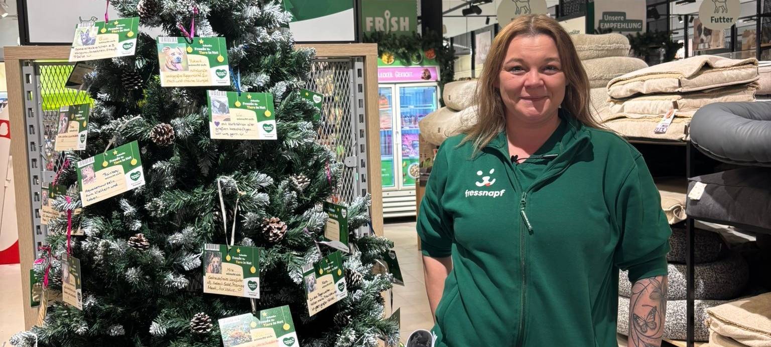 Fressnapf-Mitarbeiterin Martina mit dem Weihnachtswunschbaum für die Tiere im Tierheim.