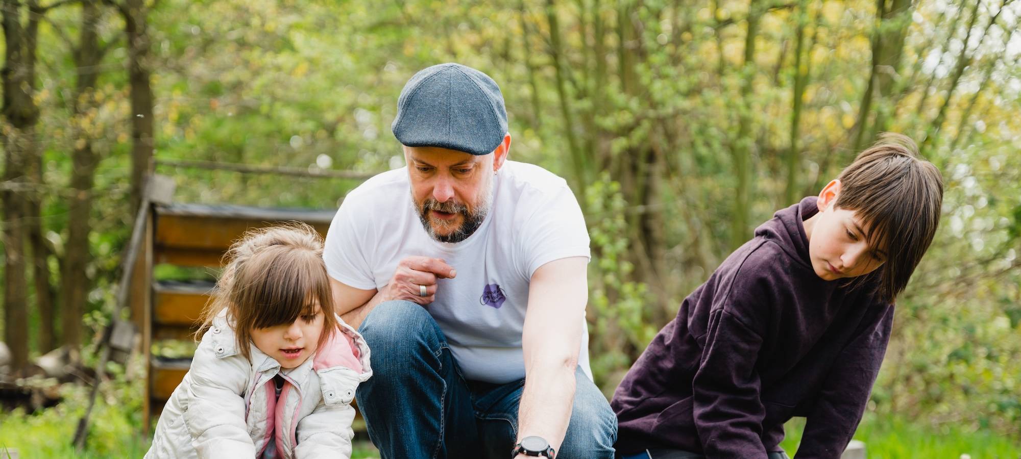Gemeinsam anpacken: Stephan Köppen, Standortleiter der Tauschbar Essen, im Garteneinsatz mit Samira und Felix.