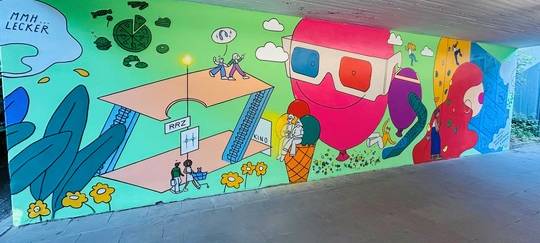 Die beiden Tunnelwände des U-Bahn-Ausgangs in Richtung Rhein-Ruhr-Zentrum in Mülheim erstrahlen in neuem Glanz – gestaltet in enger Zusammenarbeit mit dem Institut für Ausbildung in Bildender Kunst und Kunsttherapie (IBKK) Bochum.