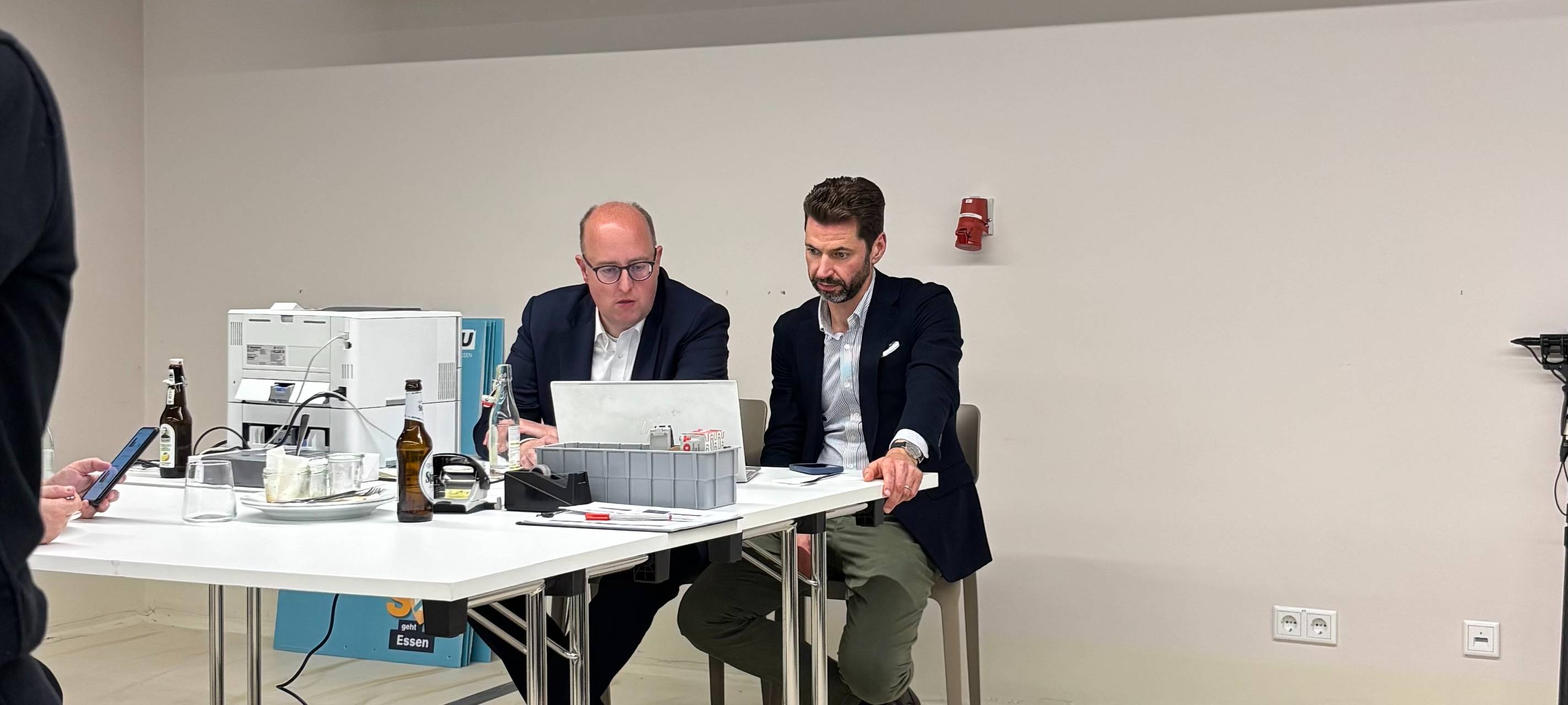 Matthias Hauer und Fabian Schrumpf von der CDU Essen schauen gebannt auf die Auszählung der Kommunalwahl-Stimmen 2025.