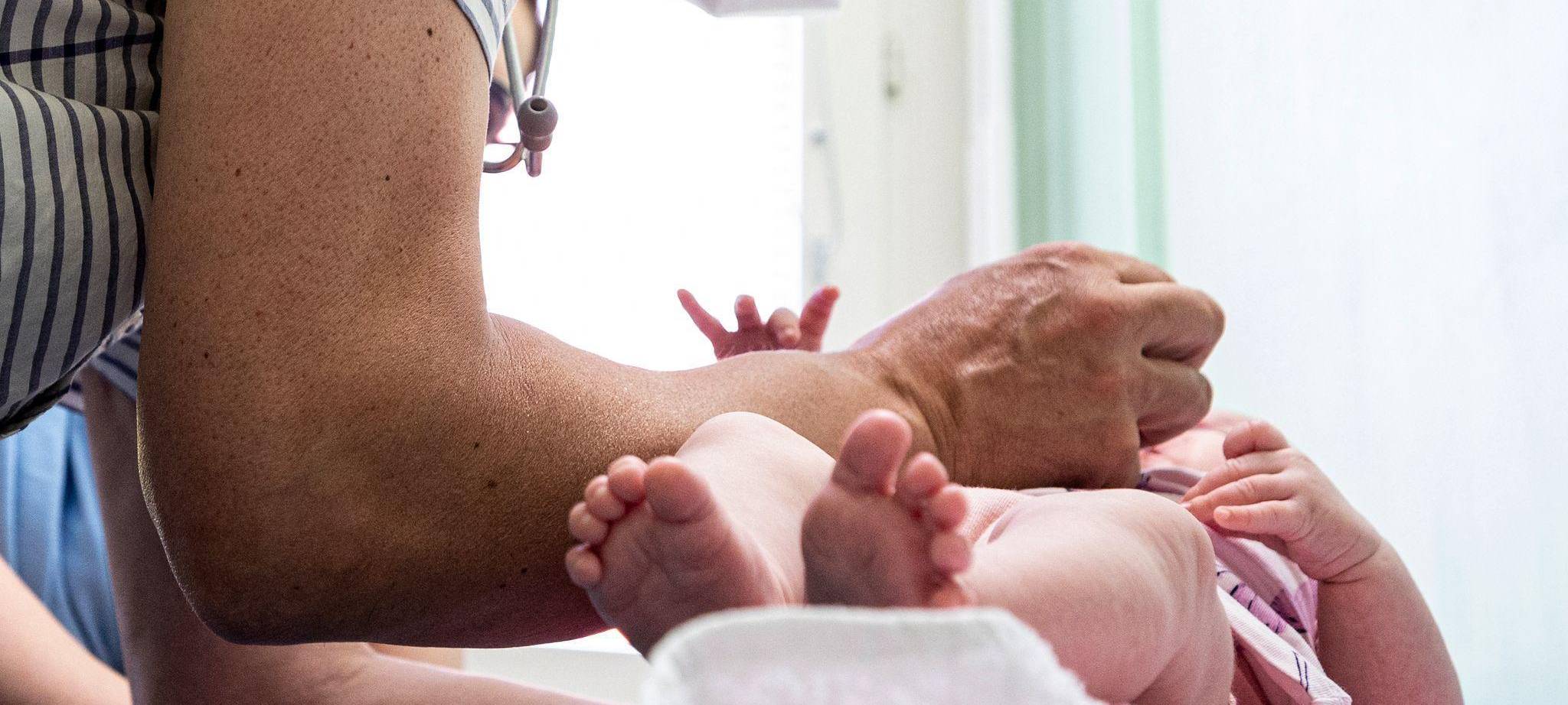Ein Kinderarzt verabreicht einem Kleinkind eine Impfung.