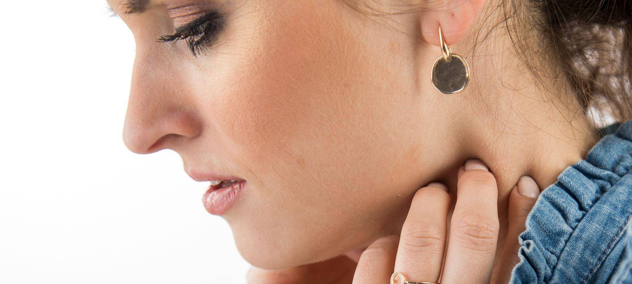 Frau fasst sich an den Hals