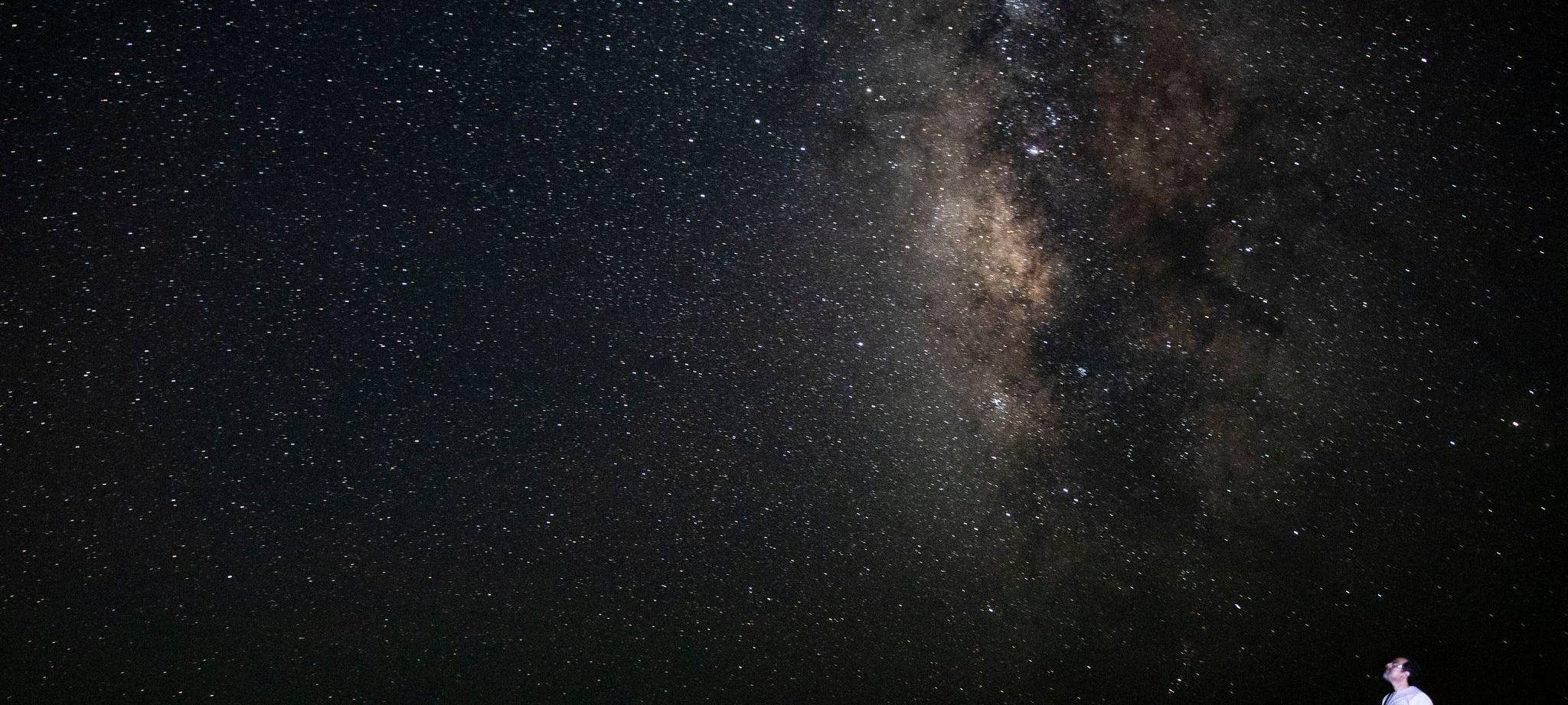 Ein Mann schaut sich den Sternenhimmel an