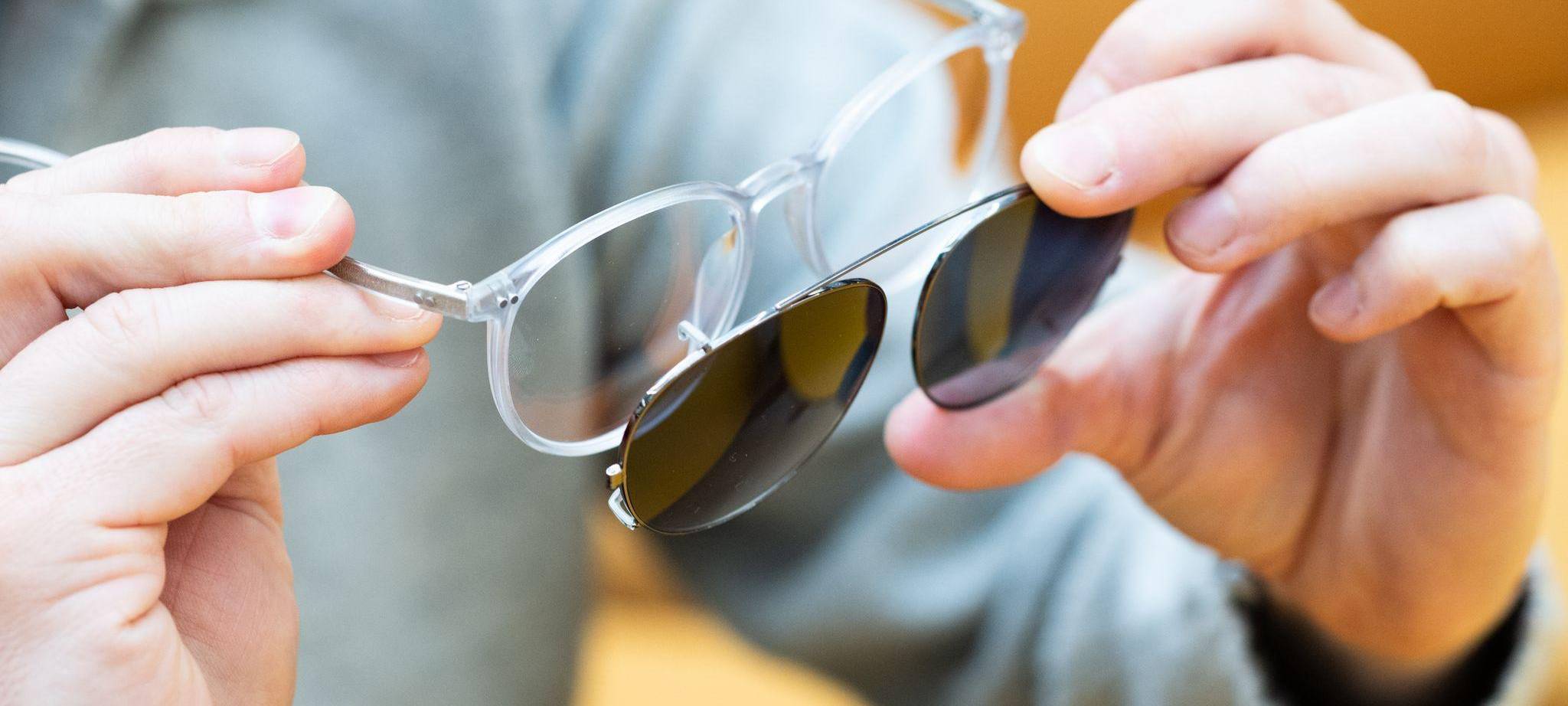 Mann befestigt Sonneclips an seiner Brille