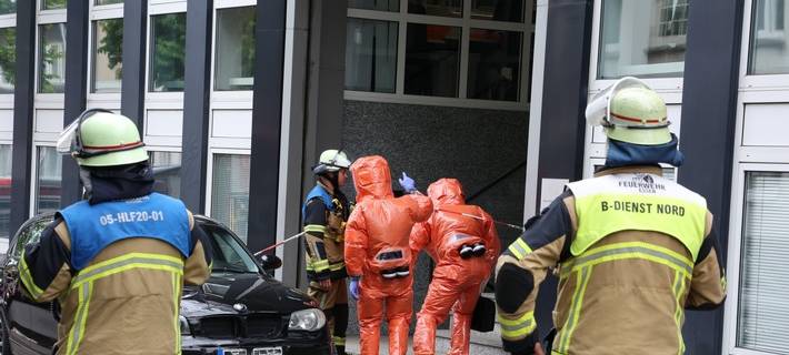 Einsatzkräfte in speziellen Schutzanzügen erkunden die Einsatzstelle im Gebäude.