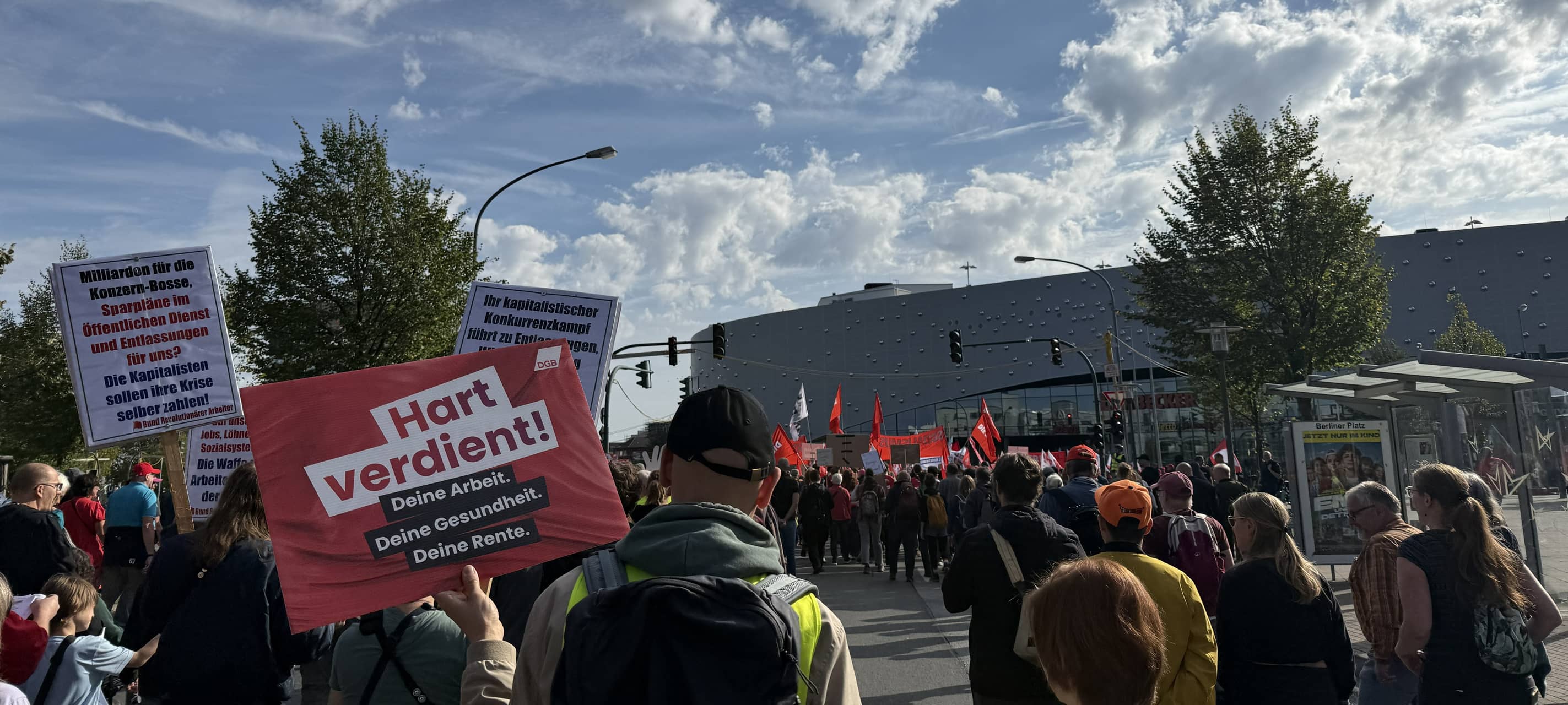 Eine Menschengruppe mit Flaggen und Schildern geht auf den Limbecker Platz zu