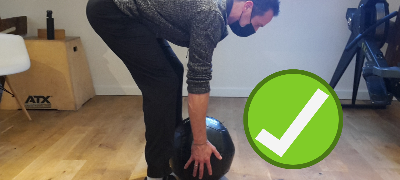 Fitnesstrainer aus Essen zeigt, wie man Sachen richtig hochhebt.