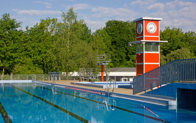 Das Sportbecken im Freibad Oststadtbad in Essen Freisenbruch mit dem typischen roten rechteckigen Turm mit Uhr.